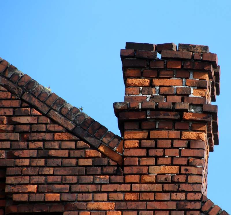 Damaged chimney on an Bell home showing cracks and missing mortar